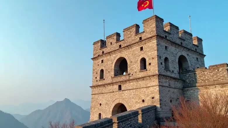Vista detalhada de uma torre de observação da Muralha da China em Mutianyu, com pedras antigas e bandeira ao vento